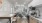 a kitchen area with stainless steel appliances and a desk with chairs