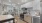 a kitchen area with stainless steel appliances and a desk with chairs